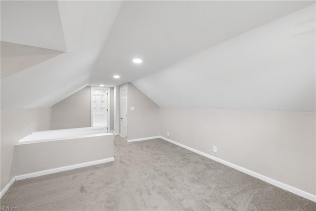 bonus room with vaulted ceiling and carpet