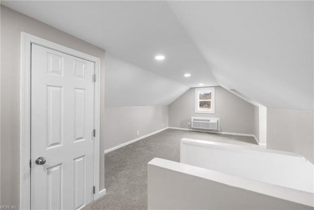 bonus room featuring lofted ceiling, a wall unit AC, and dark colored carpet