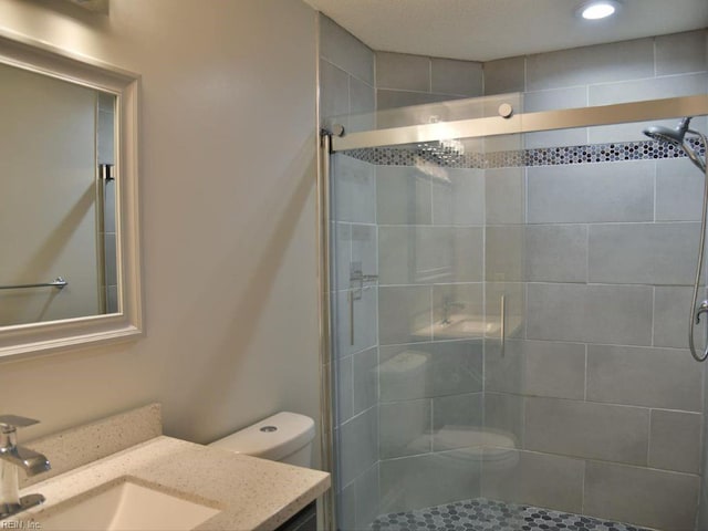 bathroom with vanity, an enclosed shower, and toilet