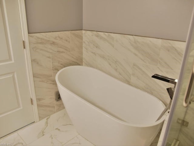 bathroom featuring tile walls and a washtub