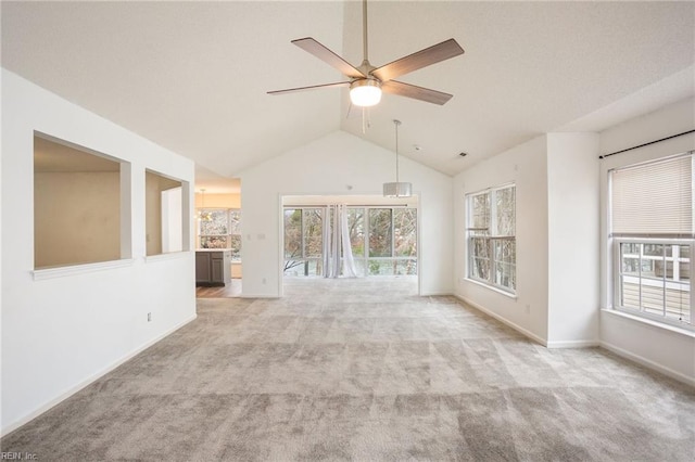 unfurnished living room featuring vaulted ceiling, light carpet, and ceiling fan