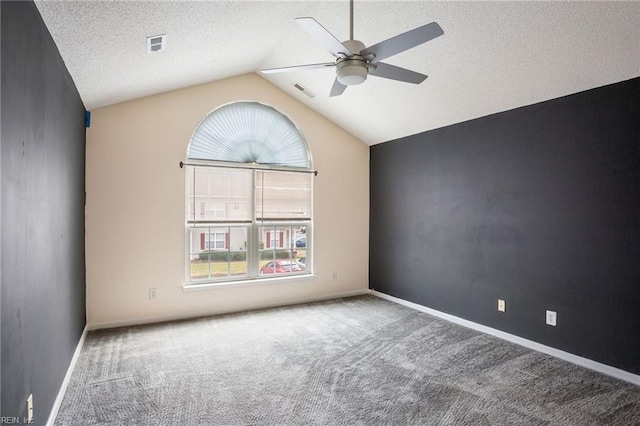 carpeted empty room featuring lofted ceiling, a textured ceiling, and ceiling fan