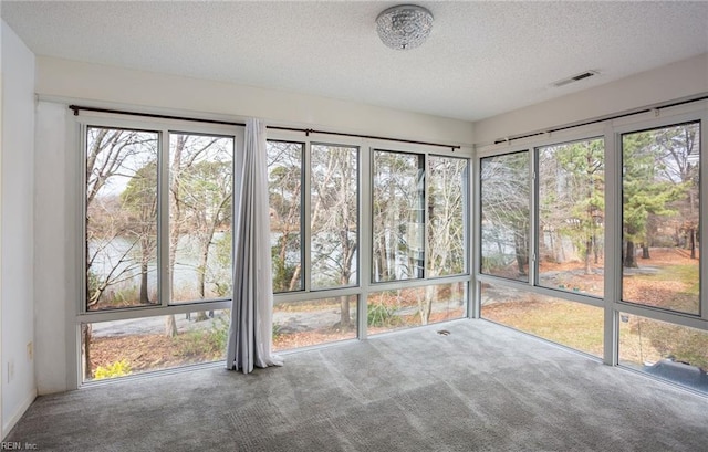 unfurnished sunroom featuring a water view