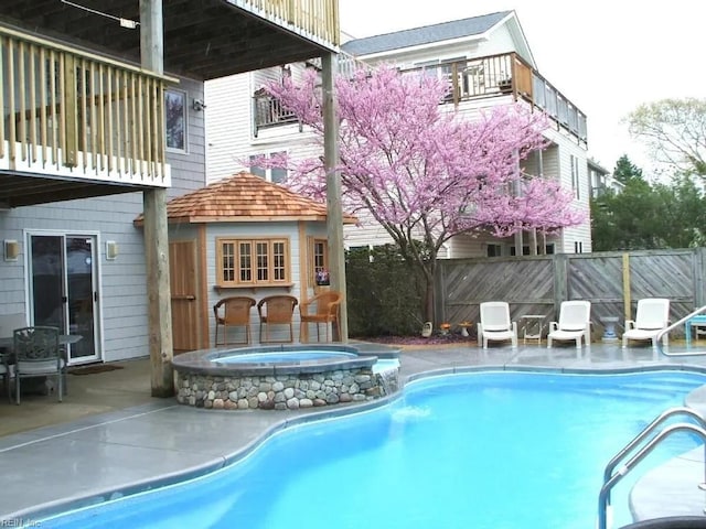 view of pool with an in ground hot tub and a patio