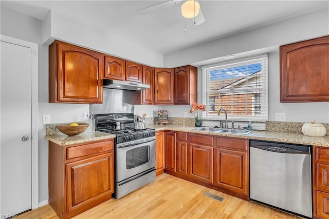 kitchen featuring light stone countertops, appliances with stainless steel finishes, sink, and light hardwood / wood-style floors