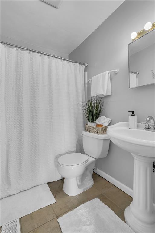 bathroom with toilet and tile patterned flooring