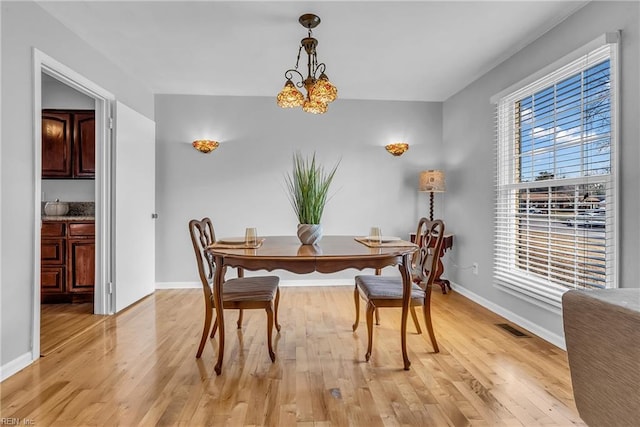 dining area featuring plenty of natural light, light hardwood / wood-style flooring, and a notable chandelier