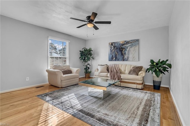 living room featuring wood-type flooring and ceiling fan