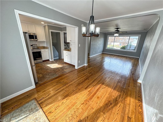 unfurnished dining area with wood-type flooring, ceiling fan with notable chandelier, and crown molding