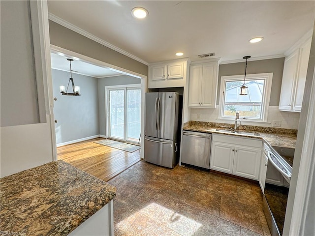 kitchen with sink, crown molding, appliances with stainless steel finishes, a wealth of natural light, and white cabinets