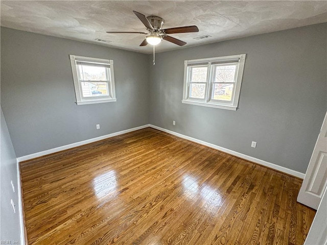 spare room featuring wood-type flooring, a textured ceiling, and ceiling fan