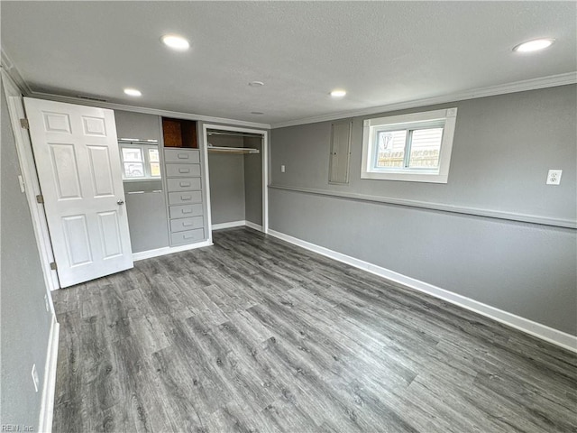 unfurnished bedroom featuring hardwood / wood-style floors, ornamental molding, and a closet