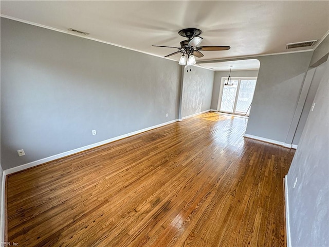 spare room with crown molding, wood-type flooring, and ceiling fan