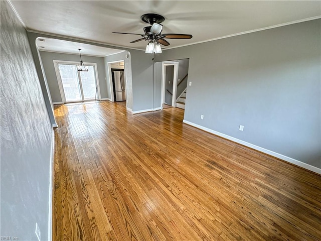 empty room featuring ceiling fan, ornamental molding, and hardwood / wood-style floors