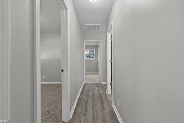 hallway with hardwood / wood-style floors