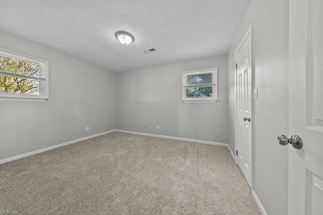 empty room featuring plenty of natural light and light colored carpet