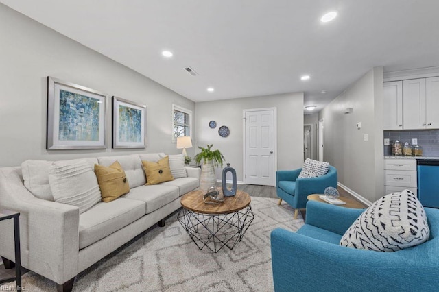 living room with light hardwood / wood-style flooring and bar area