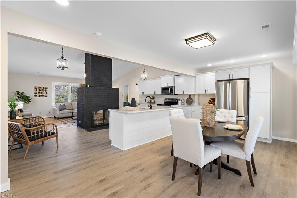 dining space with lofted ceiling, sink, light hardwood / wood-style flooring, and a fireplace