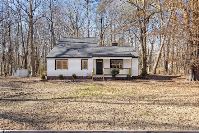 view of front of property with a porch, a front lawn, and a storage unit