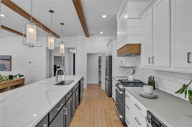 kitchen with white cabinetry, appliances with stainless steel finishes, sink, and pendant lighting