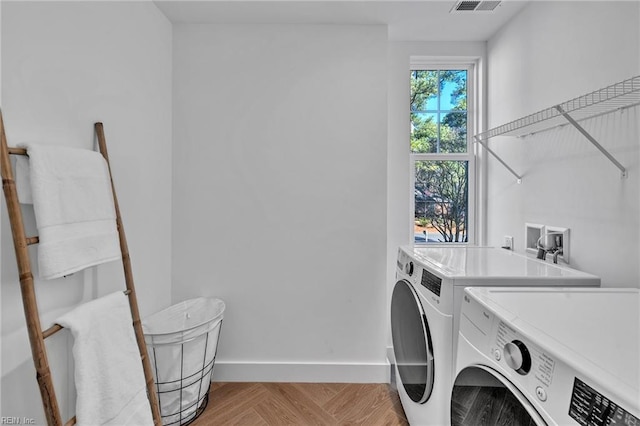 washroom featuring washer and clothes dryer and light parquet flooring