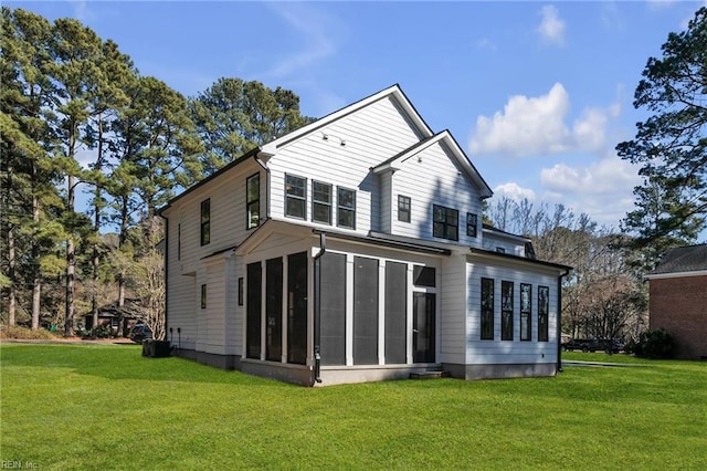 back of house featuring a yard and a sunroom