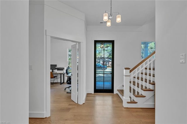 foyer with a chandelier and light hardwood / wood-style flooring