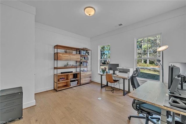 home office with light hardwood / wood-style floors