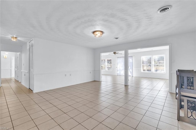 unfurnished living room featuring light tile patterned flooring and ceiling fan