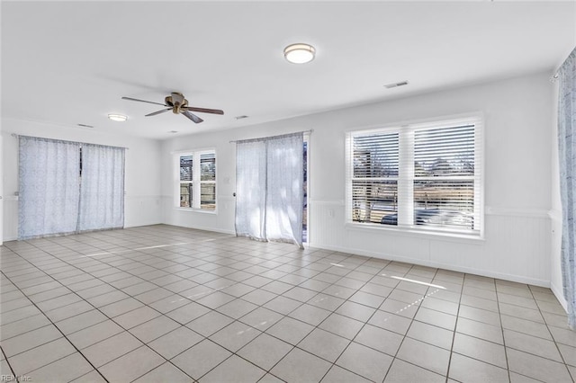 tiled spare room featuring ceiling fan