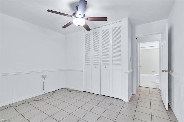 unfurnished bedroom with light tile patterned floors, a closet, and ceiling fan