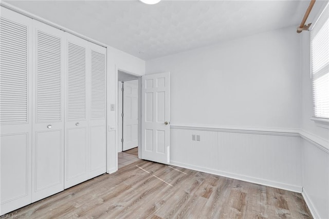 unfurnished bedroom featuring light hardwood / wood-style floors and a closet