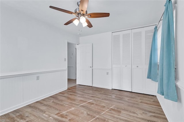 unfurnished bedroom featuring ceiling fan, light hardwood / wood-style floors, and a closet