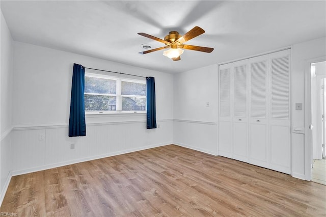 unfurnished bedroom with light hardwood / wood-style flooring, a closet, and ceiling fan