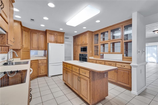 kitchen featuring light tile patterned flooring, white appliances, sink, and a kitchen island