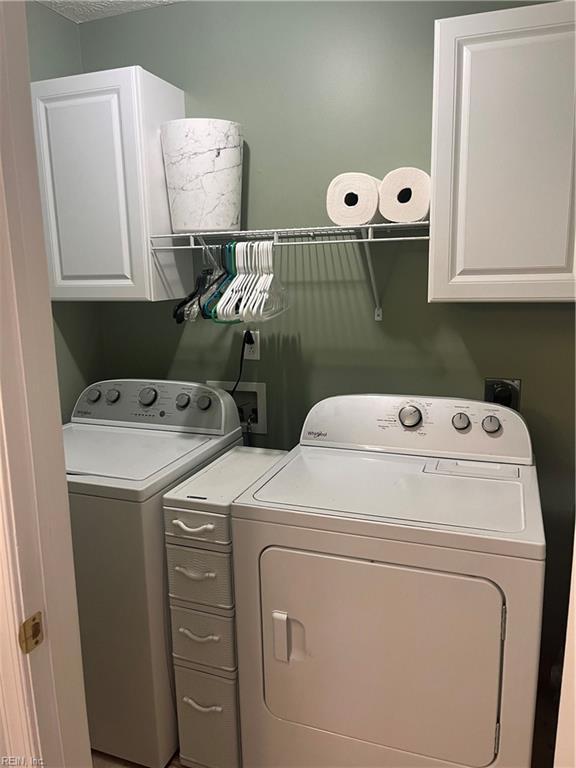 laundry room with independent washer and dryer and cabinets