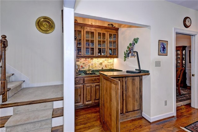 bar featuring tasteful backsplash, dark hardwood / wood-style flooring, and sink