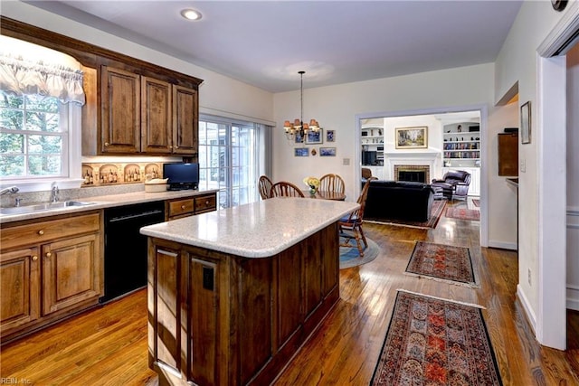 kitchen featuring sink, dark hardwood / wood-style floors, dishwasher, a kitchen island, and pendant lighting