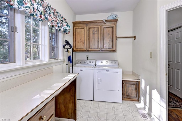 laundry room featuring independent washer and dryer and cabinets