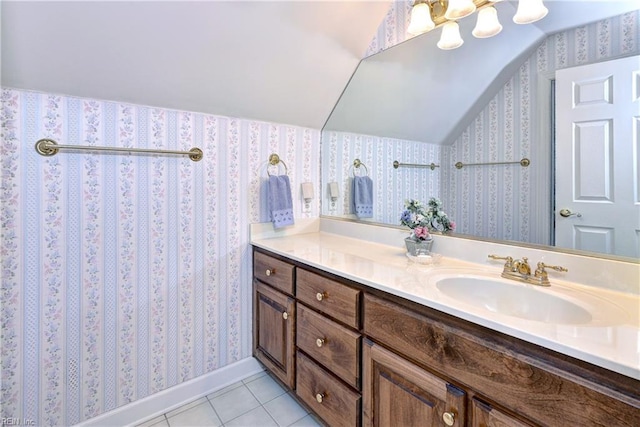 bathroom with a notable chandelier, vaulted ceiling, tile patterned floors, and vanity