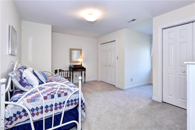 carpeted bedroom featuring two closets