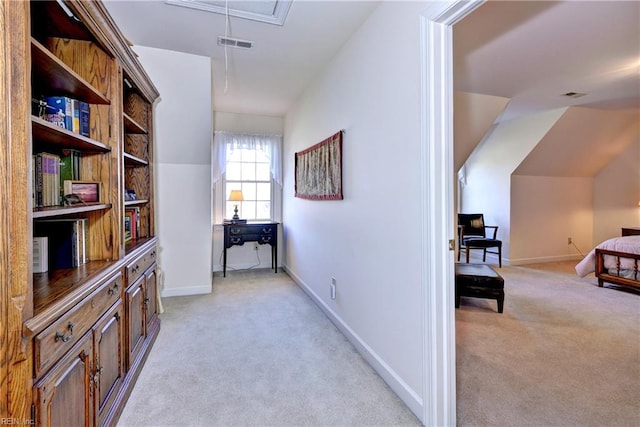 hallway with vaulted ceiling and light carpet