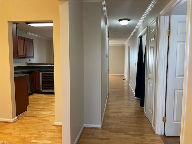 hallway with crown molding, beverage cooler, and light hardwood / wood-style flooring