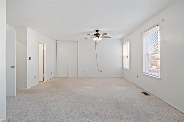 carpeted empty room featuring ceiling fan