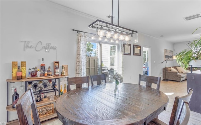 dining space featuring hardwood / wood-style floors and crown molding