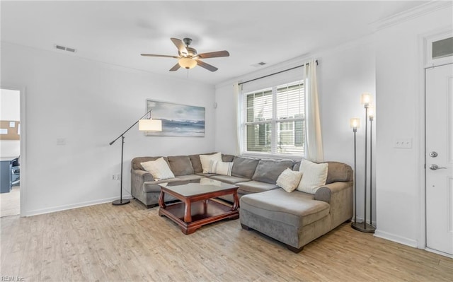 living room featuring ceiling fan, ornamental molding, and hardwood / wood-style floors