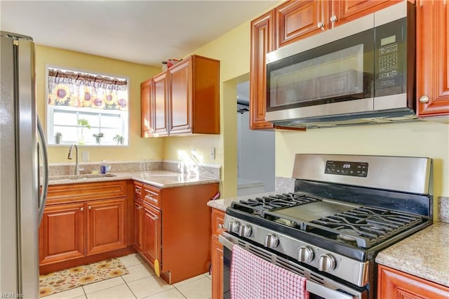 kitchen with sink, light tile patterned floors, and stainless steel appliances