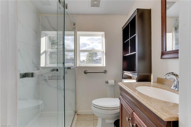 bathroom with tile patterned floors, vanity, toilet, and a shower with door