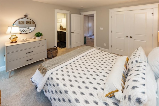 bedroom with connected bathroom, light carpet, and a closet