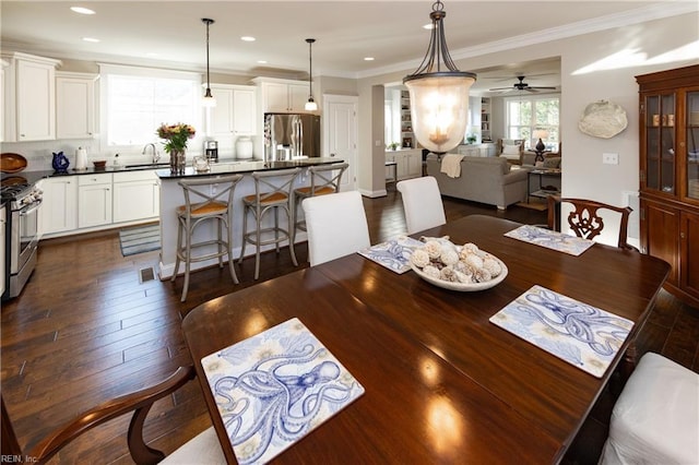 dining area with crown molding, dark wood-type flooring, and sink